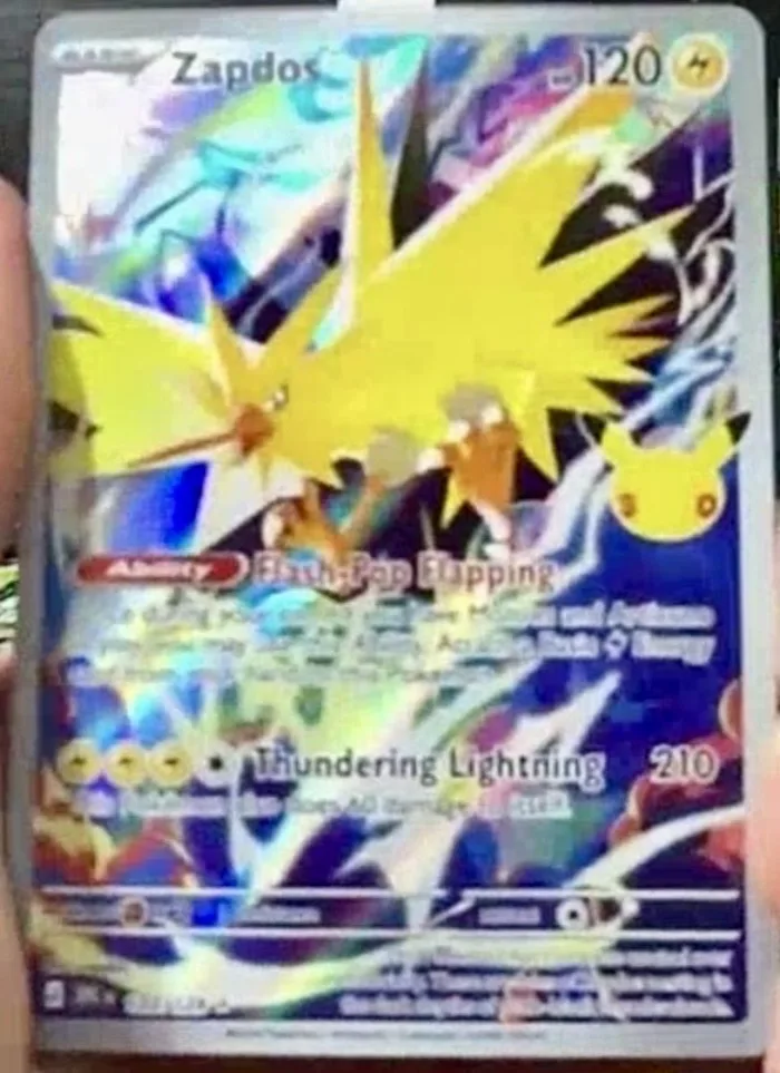 Carte Zapdos 120 PV ouverte en direct sur Whatnot, talent Flash-Pop Flapping et attaque Thundering Lightning 210, Pikachu 30 ans incrusté, extension 30e Anniversaire Pokémon