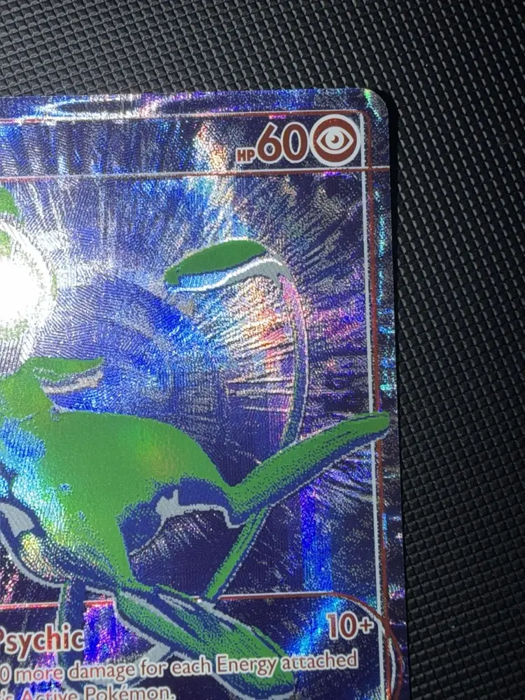 Détail du coin supérieur droit de la carte Mew B/RGB : mention HP 60 et symbole de type Psy, queue de Mew verte, texture holographique en éventail